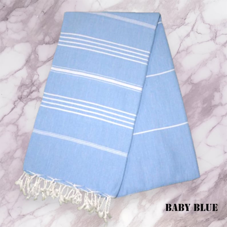 May include: A light blue Turkish towel with white stripes. The towel has fringe on the ends.