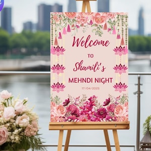 May include: A pink and white welcome sign with floral decorations and the text "Welcome to Shamili's Mehndi Night 17/04/2025".
