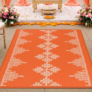 May include: A white and orange patterned wedding aisle runner with a traditional Indian design. The runner is made of a durable material and is perfect for outdoor ceremonies.