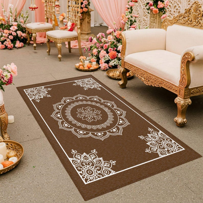 May include: A brown rectangular rug with a white mandala design. The rug is on a floor with a white and gold couch in the background.