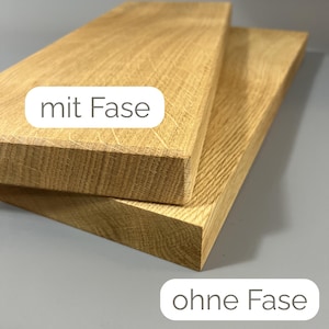 K&ouml;nnte beinhalten: Zwei rechteckige Holzbretter mit nat&uuml;rlicher Holzmaserung. Ein Brett hat eine abgeschr&auml;gte Kante, beschriftet mit "mit Fase", w&auml;hrend das andere eine gerade Kante hat, beschriftet mit "ohne Fase". Die Bretter sind hellbraun und &uuml;bereinander gestapelt.