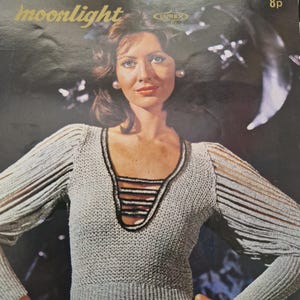 May include: A crochet pattern for a white sweater with a V-neck and long sleeves. The pattern is called "Robin Moonlight" and is number 2296. The pattern is from a vintage magazine.