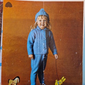 May include: A knitting pattern for a blue knitted baby outfit, including a hat, jacket, and pants. The pattern is from Patons Publications and is for a size 18 months to 2 years old, with a 22 inch chest. The pattern number is 9314.