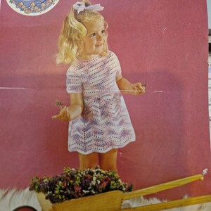 May include: A vintage crochet pattern featuring a young girl in a handmade dress. The pattern is for a 20/24 inch chest size. The image includes the Peter Pan logo and text that reads "A Crochet Design".