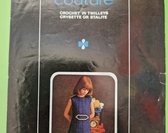 May include: A vintage crochet pattern book, "Junior Couture" by Barbara Warner. The cover shows a girl in a blue crochet dress with a gold belt. The book's cover is black with white and blue text, and the price is 6p.