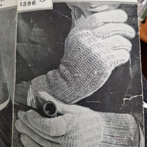 Puede incluir: Una fotografía en blanco y negro de un par de guantes tejidos. Los guantes están hechos con un patrón de punto simple y se muestran siendo usados por una persona. El texto en la página dice "Guantes para hombres en 2 y 4 agujas 2 oz. cada uno de 4 hebras" y "Bestway Leaflet 1396 3d."