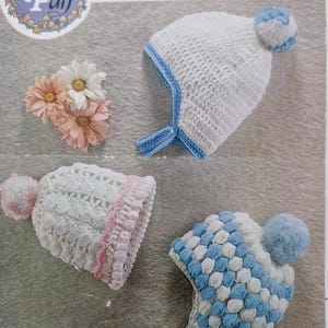 May include: Image of a vintage crochet pattern featuring three baby hats. The hats are white with blue or pink accents and pom-poms. The pattern is labeled "Peter Pan" and "Wendy design". The hats are designed for babies.