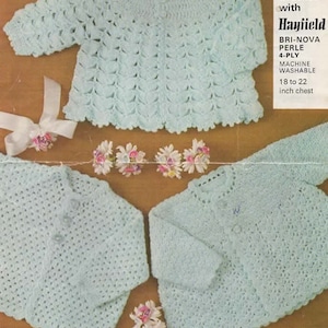 May include: A vintage crochet pattern showing three baby sweaters in a pale blue hue. The pattern includes a long-sleeved cardigan and two smaller items. The text on the pattern reads "Crochet with Hayfield" and "18 to 22 inch chest", which is approximately 46 to 56 cm.