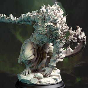 Puede incluir: Una escultura detallada y clara de una criatura mítica con cabello en forma de llama y una mano con garras que sostiene un arma. La figura está arrodillada sobre una base rocosa, con una armadura intrincada y una expresión feroz. La escultura está sobre una base negra.