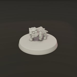 May include: A small, light-colored figurine of a creature with large eyes and a textured body. The figurine is standing on a round, flat base. The creature has a stylized, cartoonish appearance.