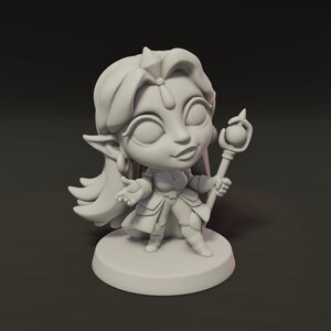 May include: A small, pale grey figurine of a fantasy character with long hair, pointed ears, and a crown. The character is holding a staff with a sphere on top and is standing on a round base. The figurine has a friendly expression.