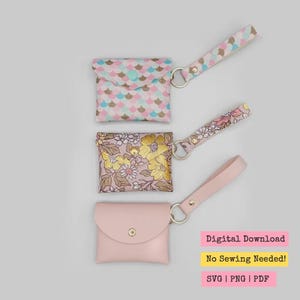 Könnte beinhalten: Drei kleine Beutel mit Handschlaufen. Der obere Beutel hat ein rosa-, blau- und goldfarbenes Schuppenmuster. Der mittlere Beutel hat ein Blumenmuster mit gelben und rosa Blüten. Der untere Beutel ist einfarbig rosa.