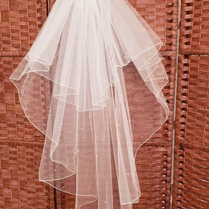 White fingertip double layer veil with pearls.