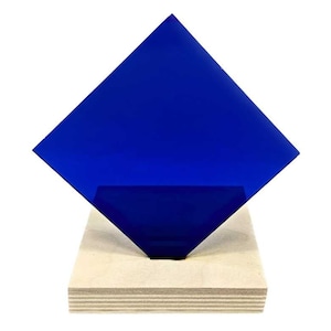 May include: A square piece of blue acrylic glass on a wooden base. The glass is translucent and has a slight sheen.