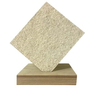 May include: A light beige, textured square panel is angled on top of a rectangular wooden base. The base is made of layered plywood. The panel appears to be made of a composite material.