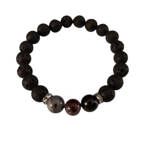 May include: A black lava rock bracelet with three accent beads. The accent beads are gray, red, and black.