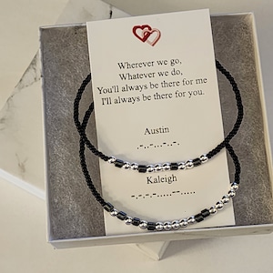 May include: Two black beaded bracelets with silver beads and a card that reads "Wherever we go, Whatever we do, You'll always be there for me I'll always be there for you. Austin Kaleigh" in braille.