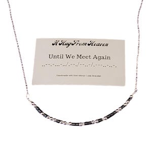 Puede incluir: Un collar plateado con una barra curva de cuentas negras y plateadas. Una tarjeta detrás del collar dice "A Hug From Heaven" y "Until We Meet Again" con código Morse. La tarjeta también dice "Handmade with love Morse Code Bracelet."