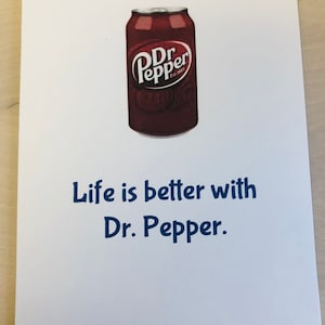 May include: A white card with a red and white can of Dr Pepper soda. The can has the text "Dr Pepper Est. 1885" on it. The text "Life is better with Dr. Pepper." is printed in blue below the can.