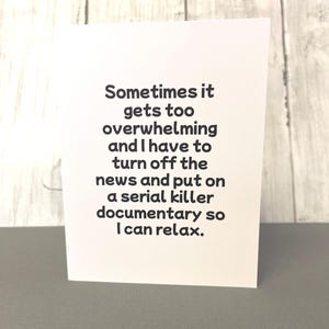 May include: A white greeting card with black text that reads: "Sometimes it gets too overwhelming and I have to turn off the news and put on a serial killer documentary so I can relax."