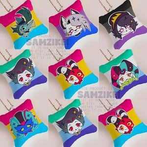 May include: A collection of nine square pillows featuring cartoon character illustrations on various pride flag backgrounds. Each pillow includes a small metal chain attachment. The text HELLUVA BOSS PRIDE PILLOW is displayed in a vertical pixelated font.