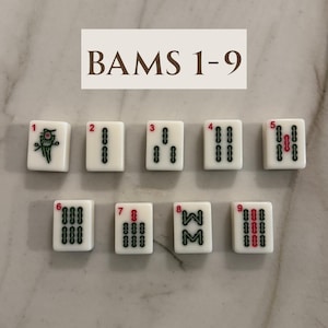 May include: Nine white Mahjong tiles, numbered 1-9, with black and red markings. The tiles are arranged in a grid, with the text "BAMS 1-9" above them. The tiles are for the "Bams" suit.
