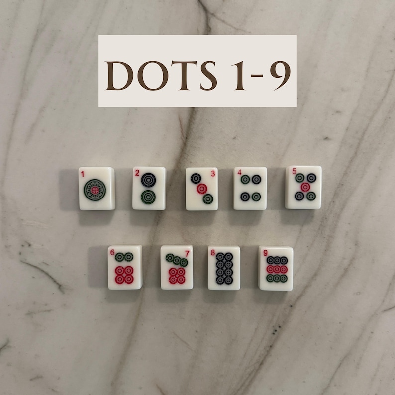 May include: A set of nine white Mahjong tiles, each displaying a number of dots from one to nine. The dots are red and green, arranged in various patterns. The text "DOTS 1-9" is at the top.
