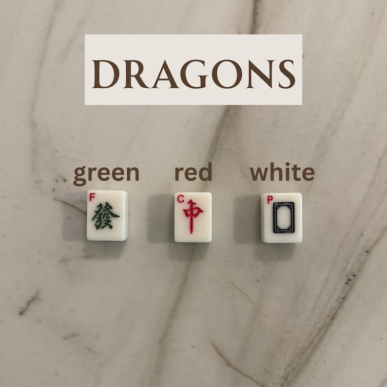 May include: Three white Mahjong tiles with green, red, and black symbols. The word "DRAGONS" is above the tiles. The tiles are labeled "green", "red", and "white".
