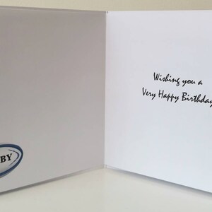 Puede incluir: Tarjeta de cumplea&ntilde;os blanca abierta con el texto "Wishing you a Very Happy Birthday" en escritura negra. Un logotipo de bal&oacute;n de rugby azul y blanco est&aacute; en el lado izquierdo de la tarjeta.