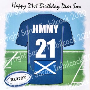 Puede incluir: Tarjeta de felicitaci&oacute;n con un dise&ntilde;o de camiseta de rugby azul. La camiseta tiene el nombre "JIMMY" y el n&uacute;mero "21" en la espalda. La bandera escocesa est&aacute; presente. Tambi&eacute;n est&aacute;n las palabras "Happy 21st Birthday Dear Son" y "RUGBY".