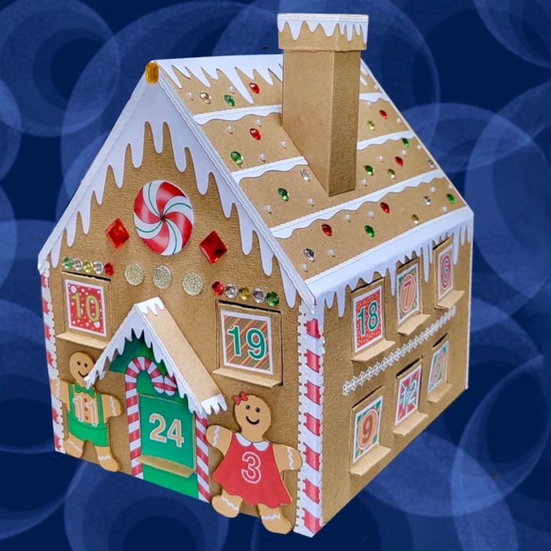 May include: A cardboard gingerbread house advent calendar with 24 numbered windows. The house is decorated with candy canes, red and green sprinkles, and rhinestones. There are gingerbread people on either side of the house.