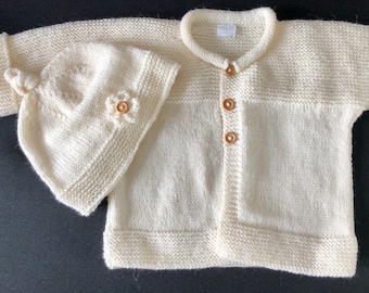 Hand knitted wool baby jacket and hat.