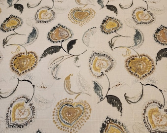 May include: Cream-colored fabric with a repeating pattern of stylized floral and heart-shaped designs. The flowers and hearts feature shades of yellow, brown, and blue, with black stems and leaves. The overall design has a vintage or bohemian aesthetic.