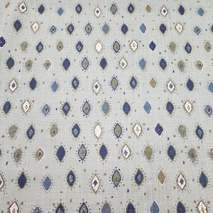 May include: A light blue fabric with a repeating pattern of diamond shapes in shades of blue, green, and white.