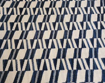 May include: A white fabric with a geometric pattern of blue triangles. The pattern is repeated throughout the fabric.