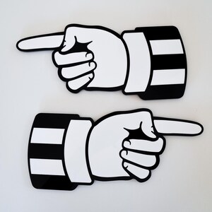 May include: Two black and white pointing hand signs. The hands are pointing to the right. The signs are made of a thick, durable material.
