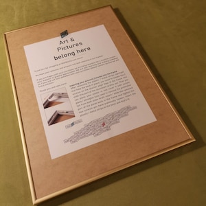 May include: A close-up of a framed picture with instructions on how to insert artwork or photos into the frame. The instructions include removing the plastic or metal strips, loosening screws, and sliding the artwork into the frame.