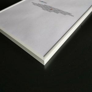 May include: A white picture frame with a white mat and a white background. The frame is on a black surface.