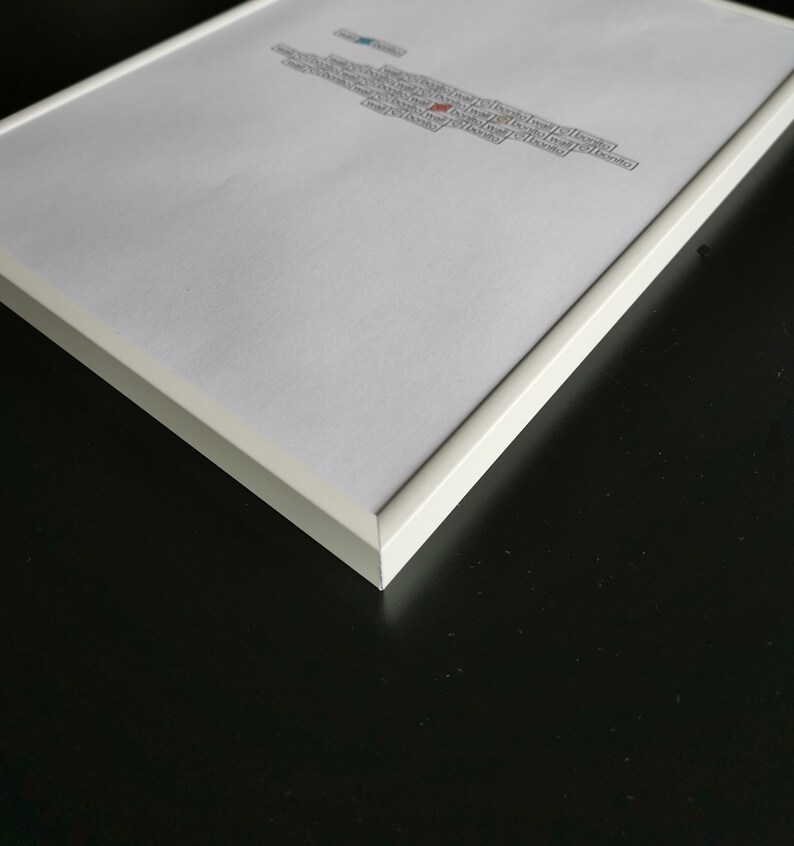 May include: A white picture frame with a white mat and a white background. The frame is on a black surface.