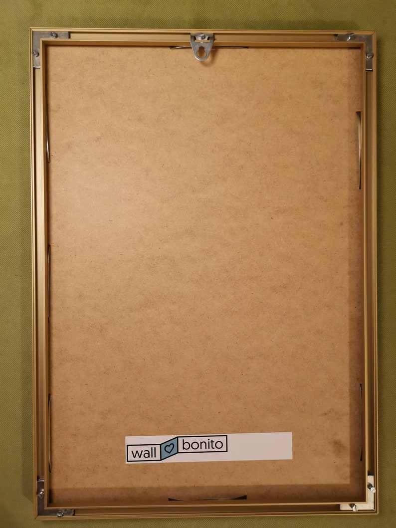 Peut inclure: Un cadre photo dor&eacute; avec un fond brun. Le cadre a un crochet de suspension en haut et un autocollant en bas qui dit "wall &hearts; bonito".