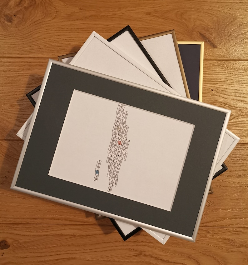 May include: A framed print with the text "wal bonito" repeated in a pattern. The print is framed in a silver frame with a black mat.