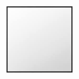 May include: Square mirror with a black frame. The mirror has a clean, reflective surface and a simple, modern design. The black frame provides a defined border.