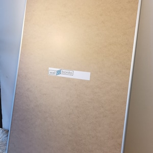 May include: A large, rectangular, silver-framed corkboard with a white sticker that says "wall &hearts; bonito".