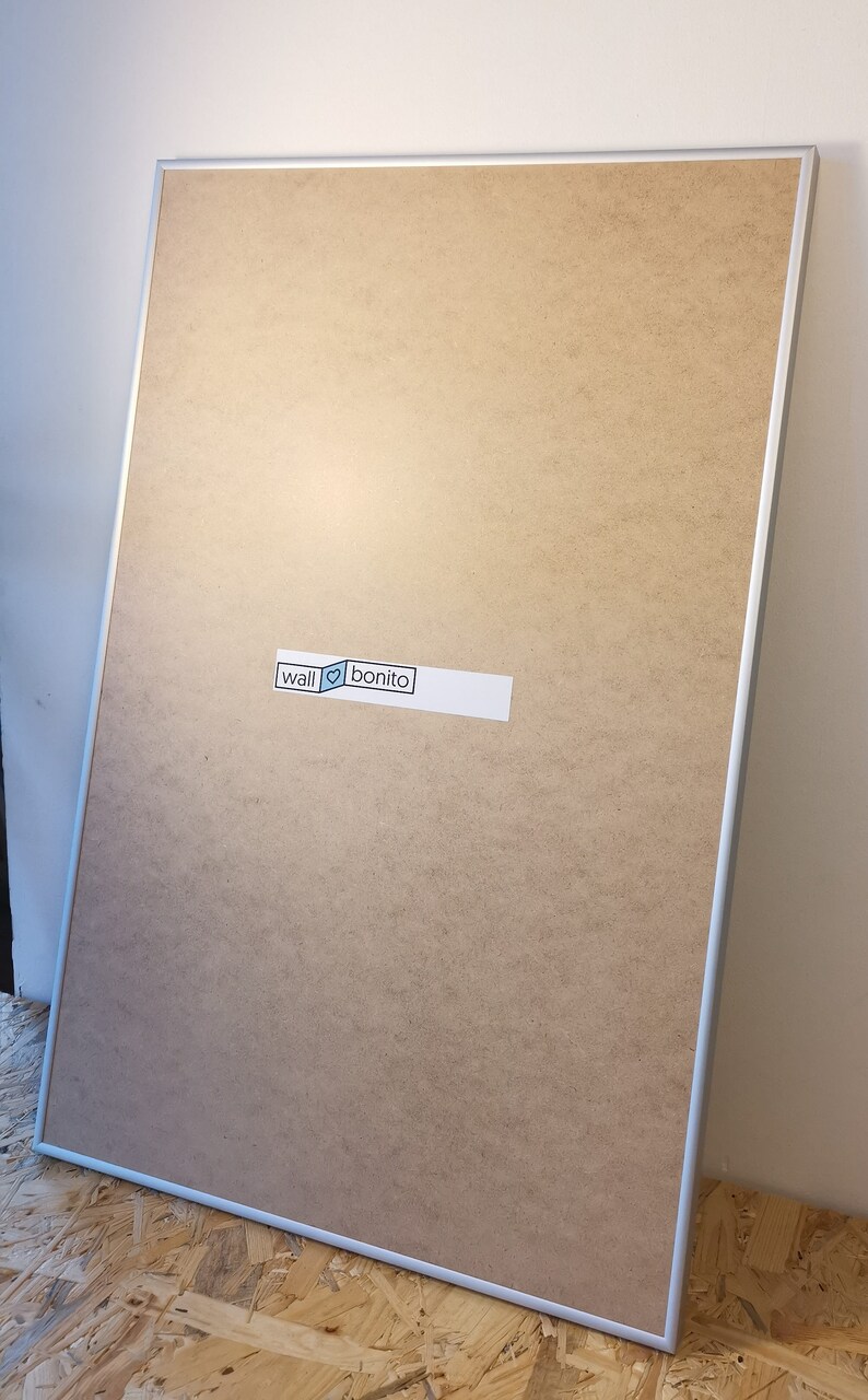May include: A large, rectangular, silver-framed corkboard with a white sticker that says "wall &hearts; bonito".