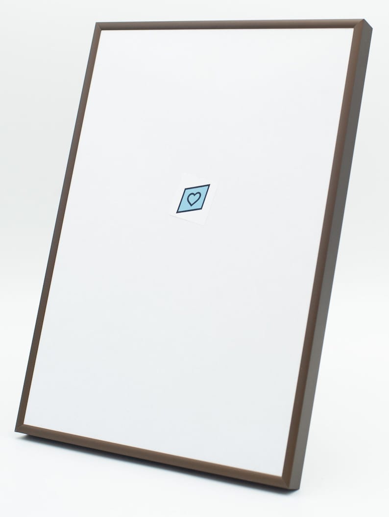 May include: A brown picture frame with a white mat and a small blue heart sticker in the center.
