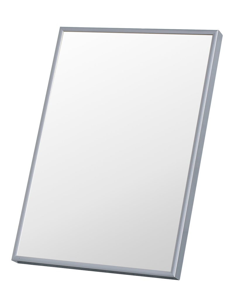 May include: A rectangular mirror with a silver frame. The mirror is angled slightly, showcasing its reflective surface. The frame is a simple, modern design, suitable for various decor styles. The mirror is a home decor item.