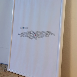 May include: A white framed picture with the words "wall bonito" repeated in a pattern. The words are in black and white and are arranged in a diagonal pattern.