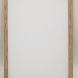 Op de afbeelding: Een natuurlijke houten fotolijst met een lichtbruine afwerking. De lijst is leeg en klaar om een foto of kunstwerk te tonen.