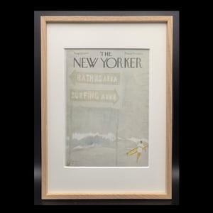 Könnte beinhalten: Ein gerahmtes, vintage New Yorker Magazin-Cover vom 25. August 1979 mit einer Strandszene, die Schilder für Bathing Area und Surfing Area zeigt. Eine Person trägt ein gelbes Surfbrett am Wasser. Der Druck ist in einem hellen Holzrahmen mit weißem Passepartout.