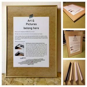 May include: A gold-colored picture frame with a white mat and a printed sheet of paper inside. The paper has the text "Art & Pictures belong here" and instructions on how to insert artwork into the frame. The frame is sitting on a white surface.